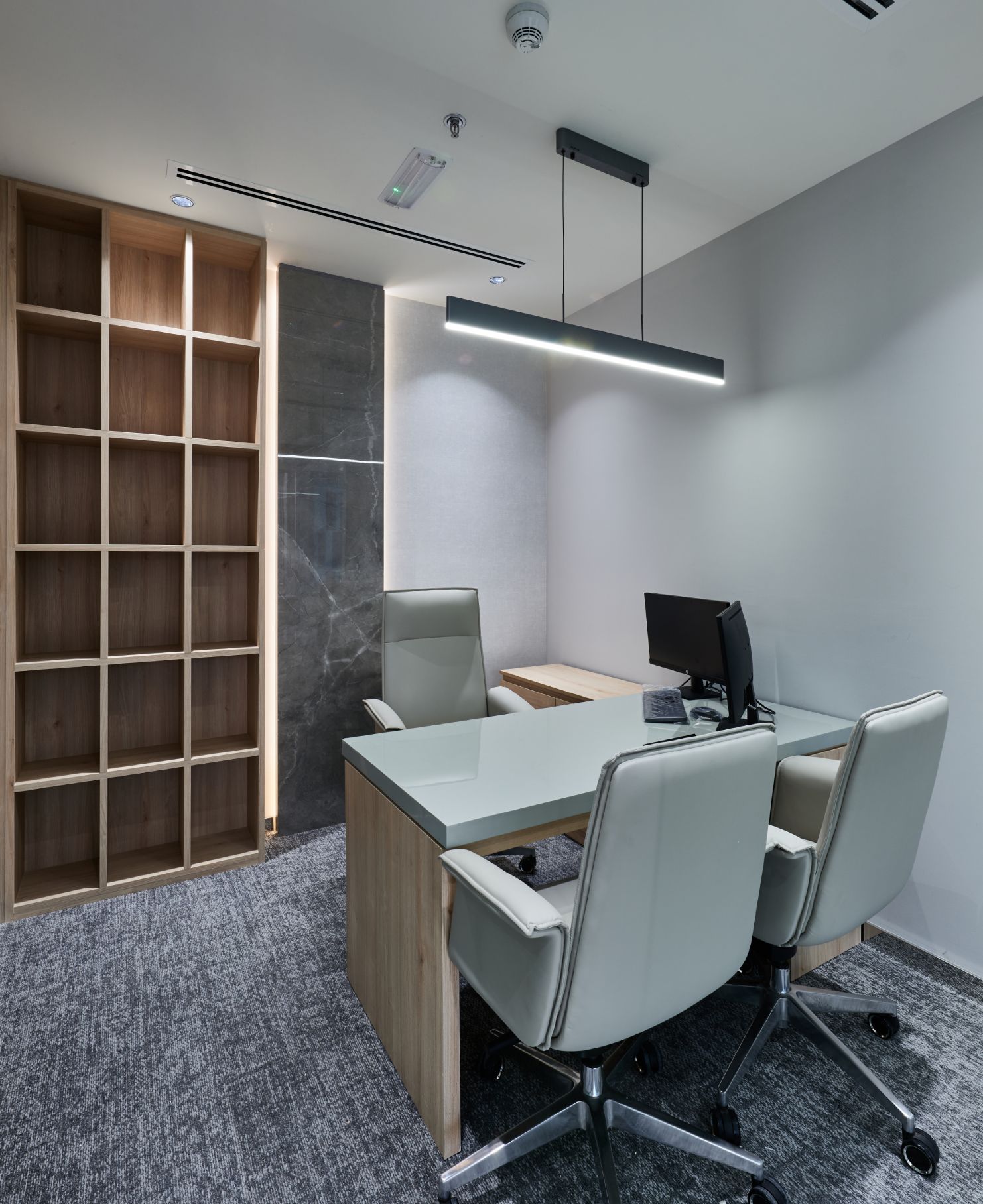 Contemporary office workspace featuring custom wood joinery and minimalist design at OGIER Financial Tower